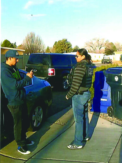 A young man in a hat films person standing near him with his cell phone