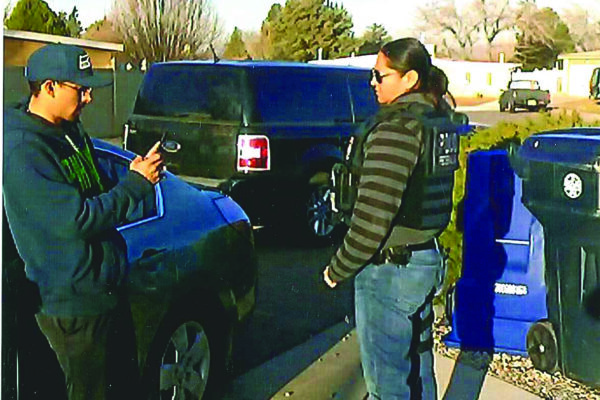 A young man in a hat films person standing near him with his cell phone