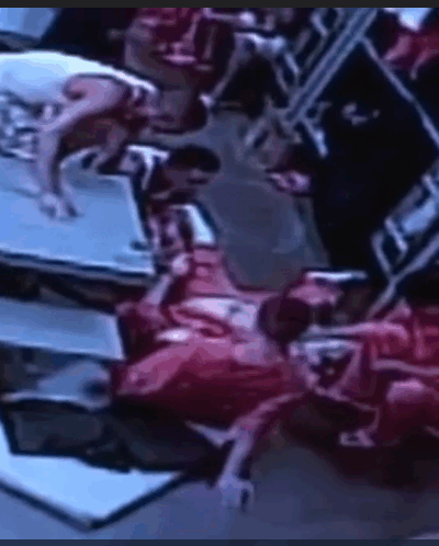 Fellow inmates tend to Douglas Edmisten as he lays on the ground in pain.