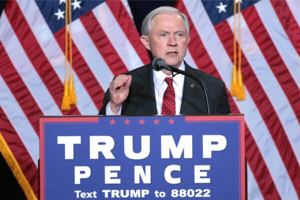 AG Jeff Sessions behind a podium speaking at a Trump Pence political rally