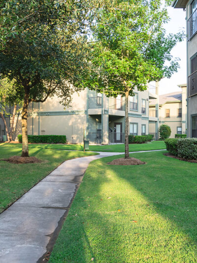 Clean lawn and tidy oak trees in front of an apartment complex