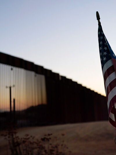 A flag sits just north of a new section of the US-Mexico border structure