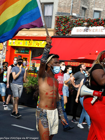 Trans activists march at the Black Transnational Rally with a rainbow flag in the West Village of Manhattan.