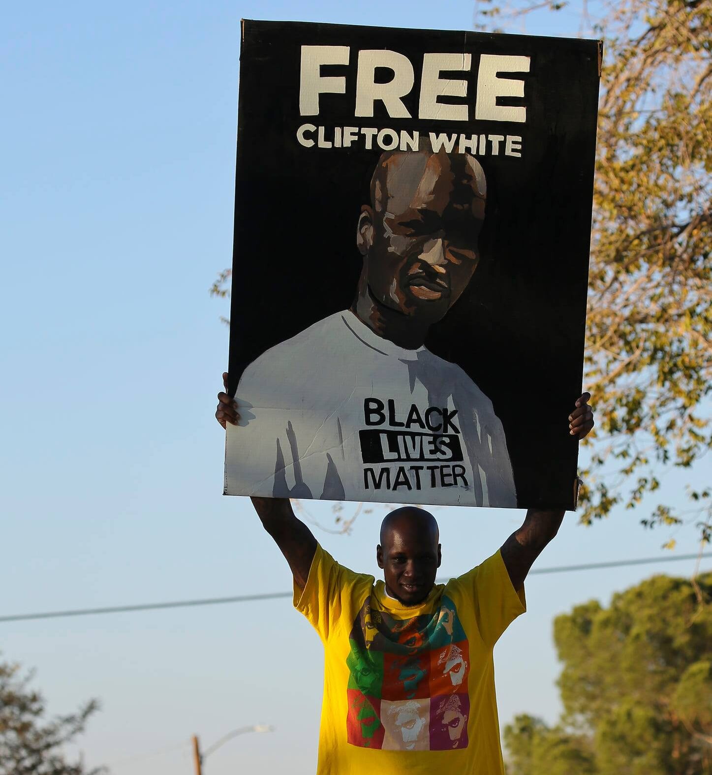 Photo of Clifton White holding a "free Clifton White" poster