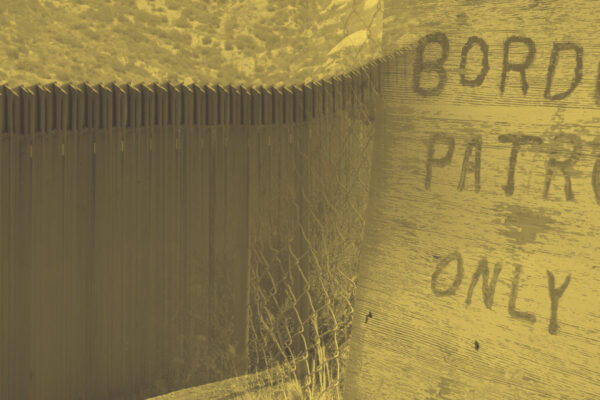 A sign that says border patrol only with a border fence.