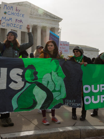 A group of demonstrators holding a banner saying "Our Bodies, Our Freedom."