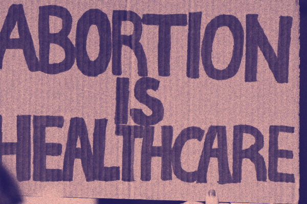 Stylized image of someone holding up a sign that reads "Abortion is healthcare"