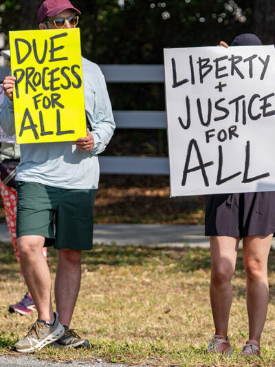 A protest with individuals holding signs in favor of due process.