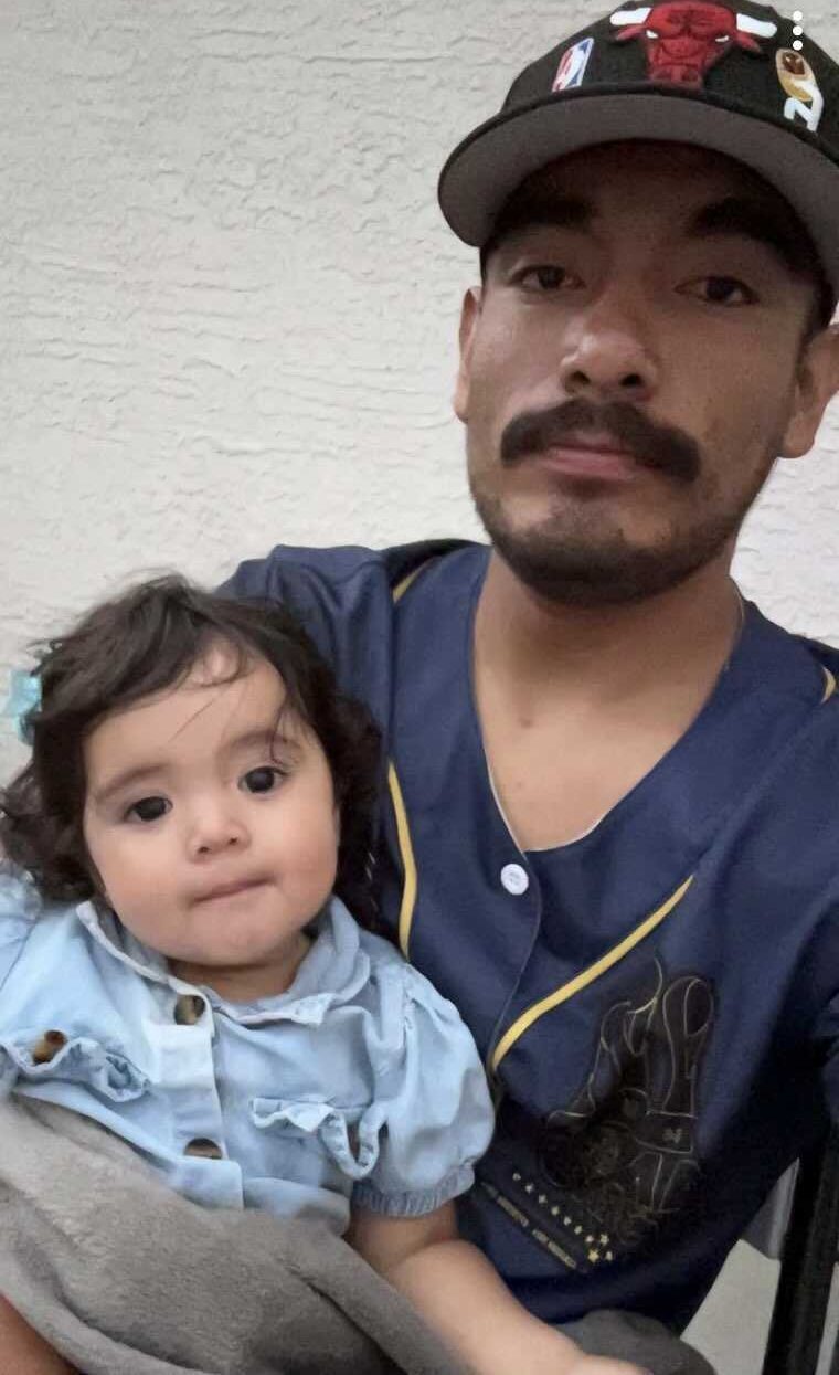Image of Juan holding his daughter