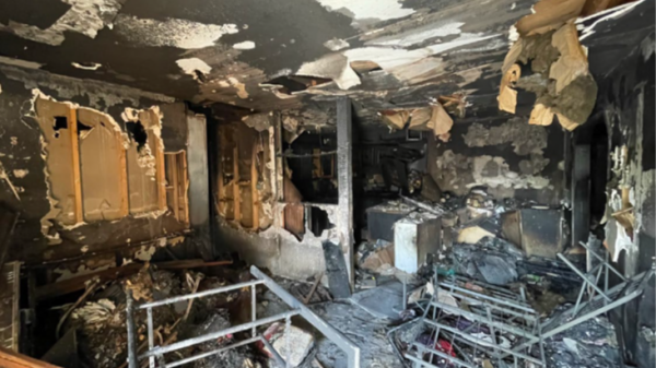 photo taken of the charred remains of the Coleman's home. Various items of burned material are shown among the soot.