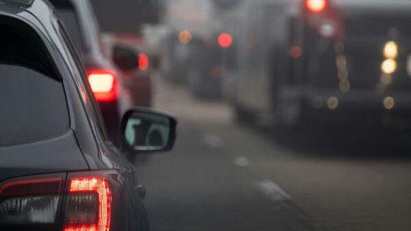 Cars on a roadway with lots of traffic.