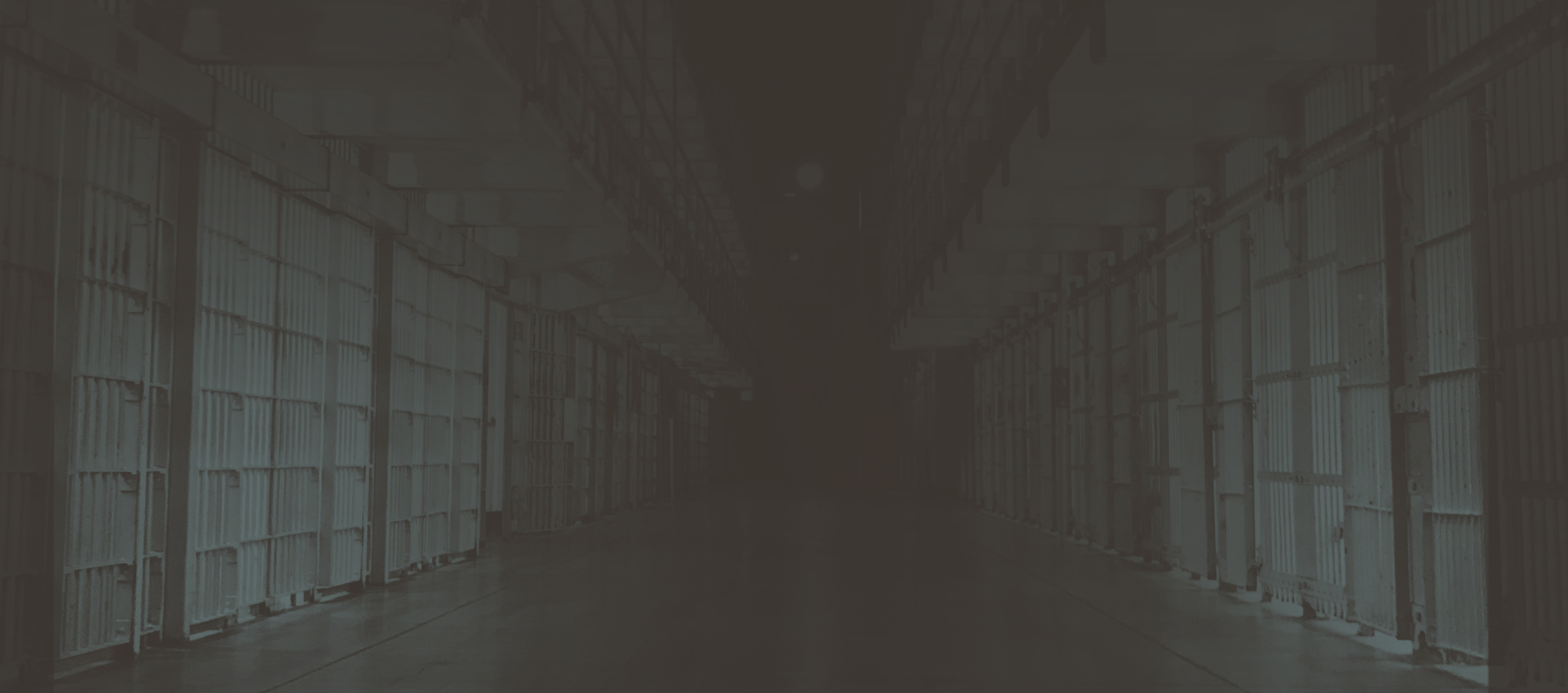 Dark hallway with prison cells.