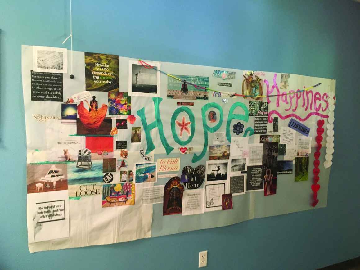 Photo: a mural made of different types of media featuring the words hope and happiness hangs on a wall
