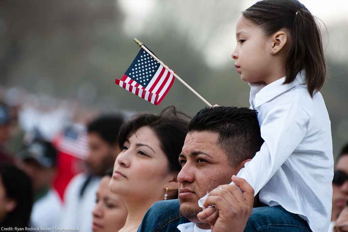 A girl and her father stand with some 200,000 immigrants' rights activists flood the National Mall to demand comprehensive immigration reform on March 21, 2010 in Washington DC.