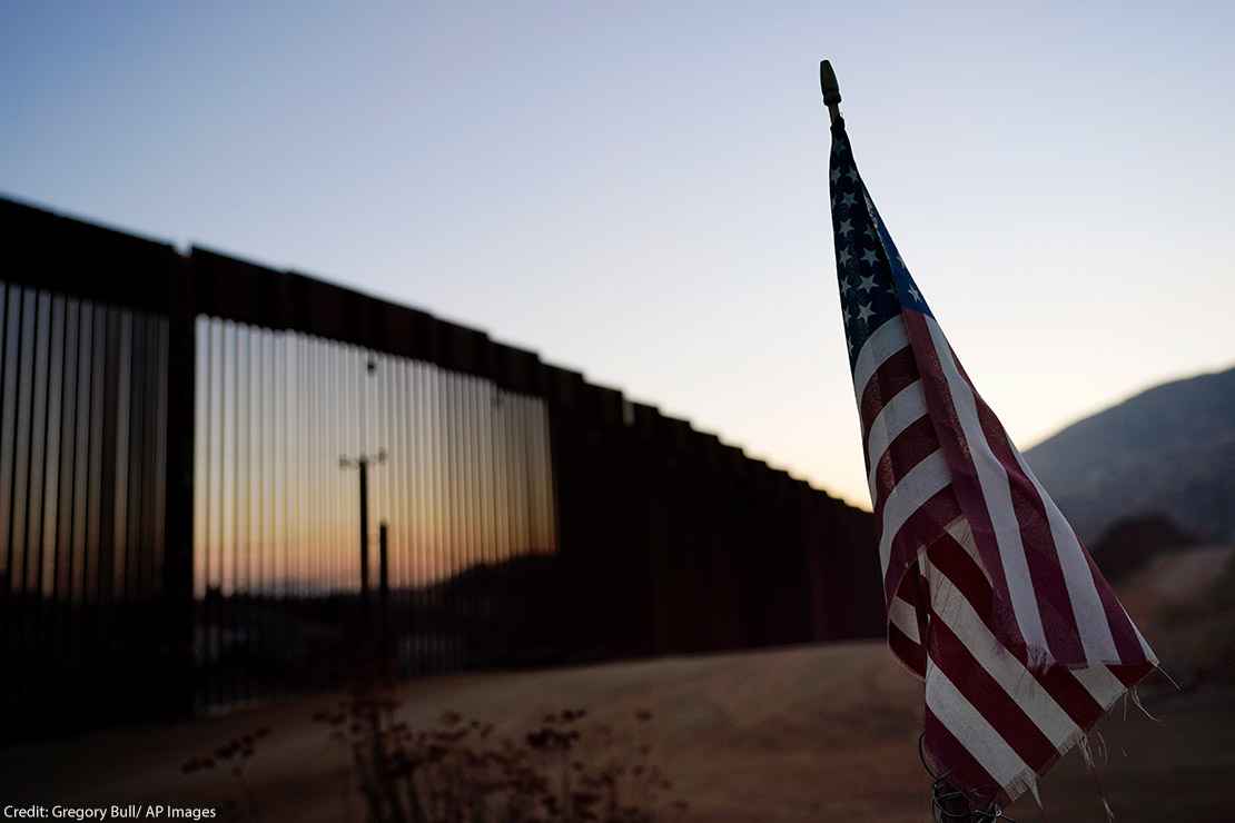 A flag sits just north of a new section of the US-Mexico border structure