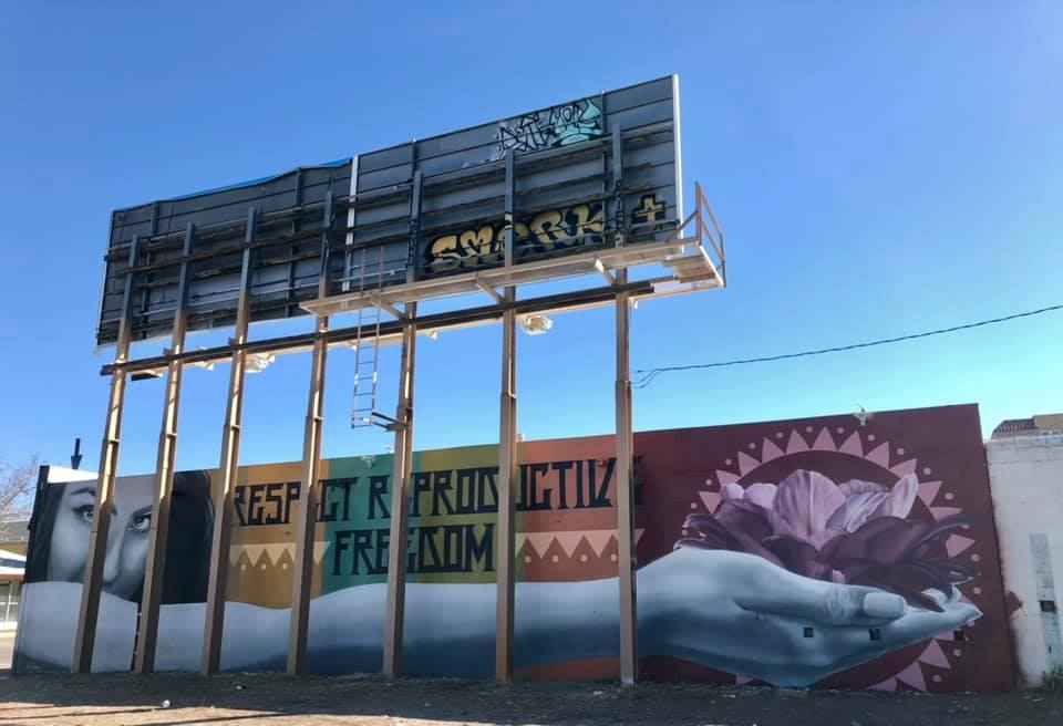 Image of mural featuring a woman holding a cactus blossom with caption "Respect Reproductive freedom"