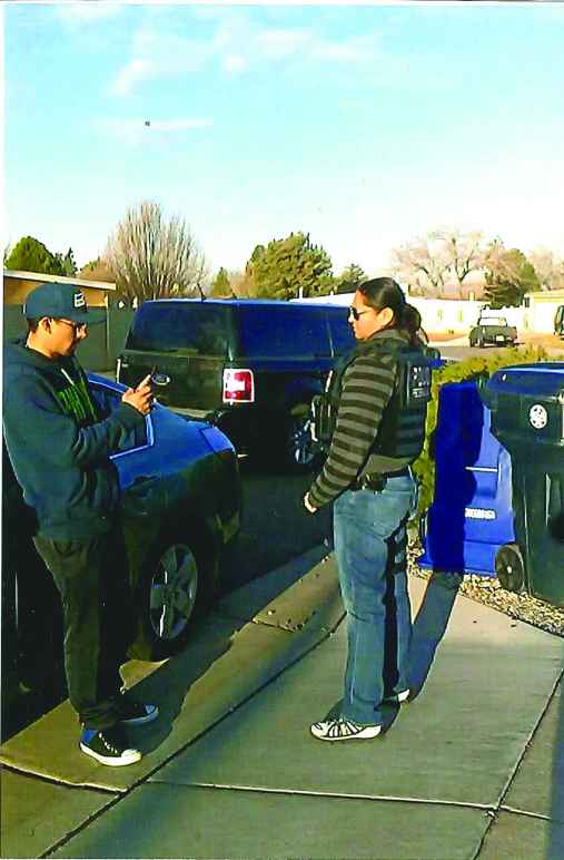 A young man in a hat films person standing near him with his cell phone