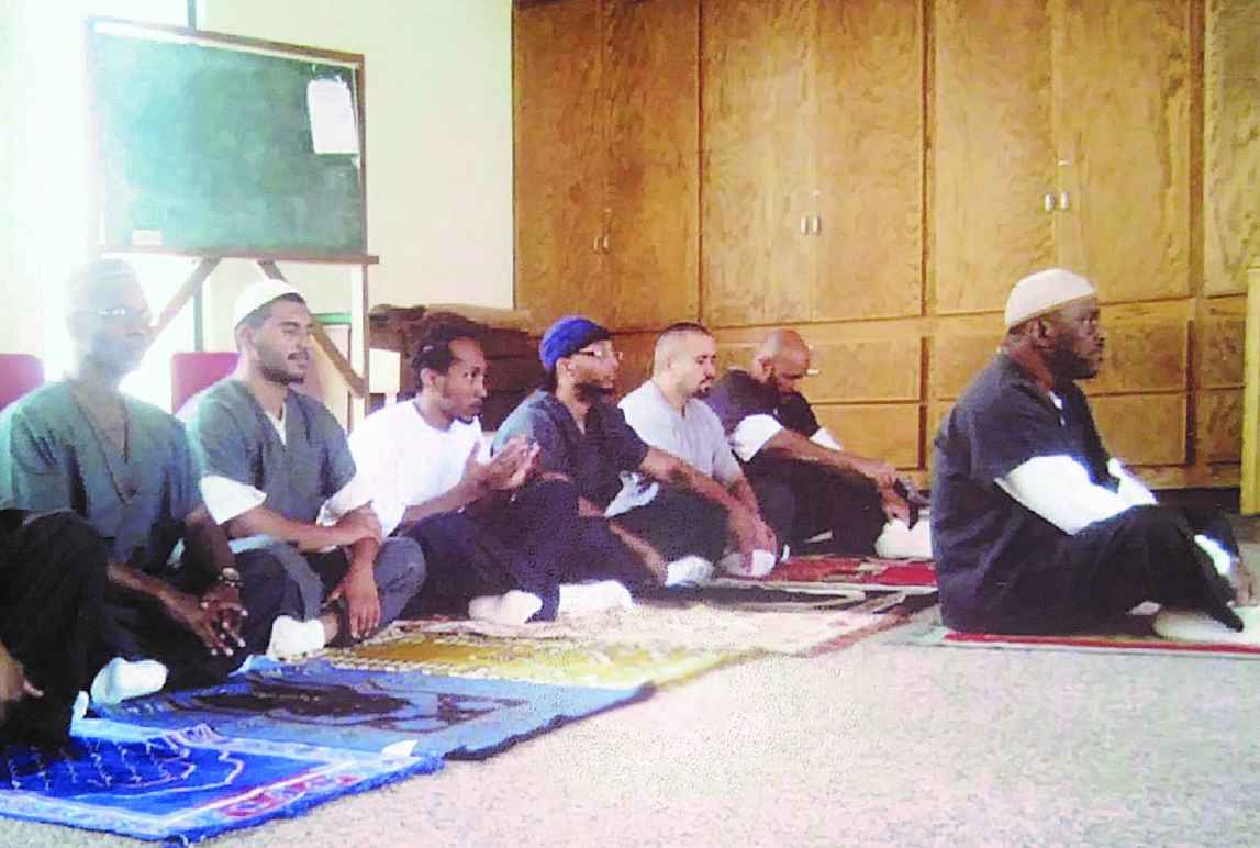 Tremaine praying alongside fellow inmates 