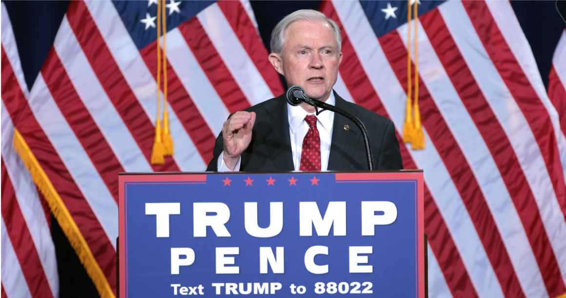 AG Jeff Sessions behind a podium speaking at a Trump Pence political rally