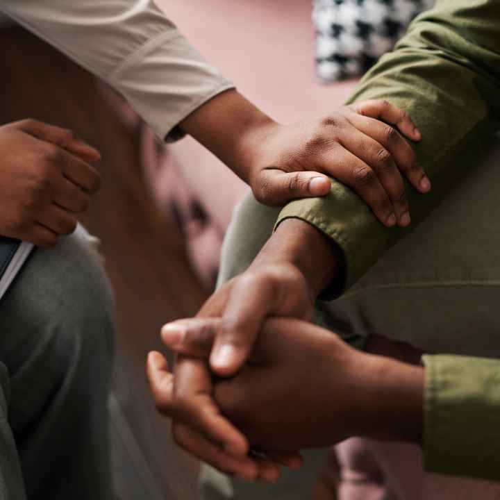 This image shows a close-up of two people engaging in a supportive, comforting interaction.