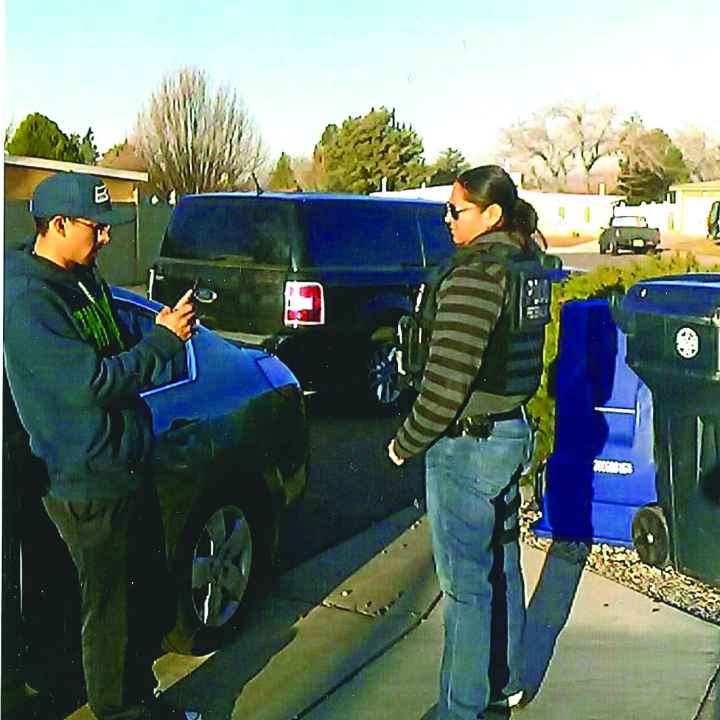 A young man in a hat films person standing near him with his cell phone