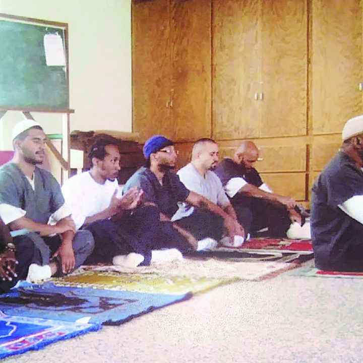 Tremaine praying alongside fellow inmates 